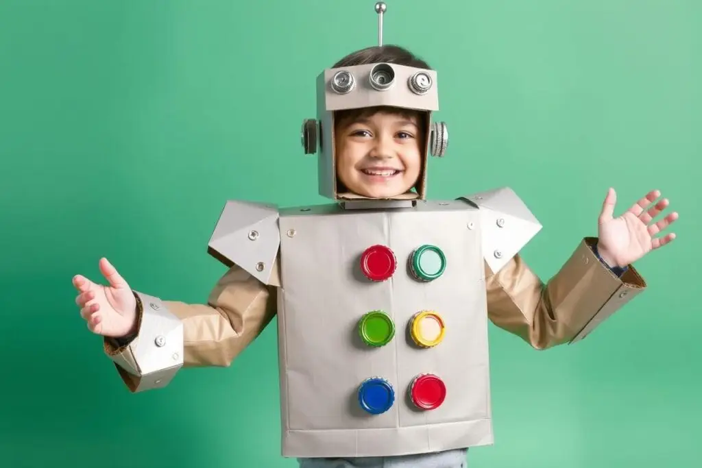 Chłopiec w stroju robota wykonanym z kartonów pomalowanych na srebrno Chłopiec w stroju robota wykonanym z kartonów pomalowanych na srebrno