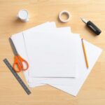 Materiały potrzebne do wykonania czapki kucharskiej z papieru ułożone na stole