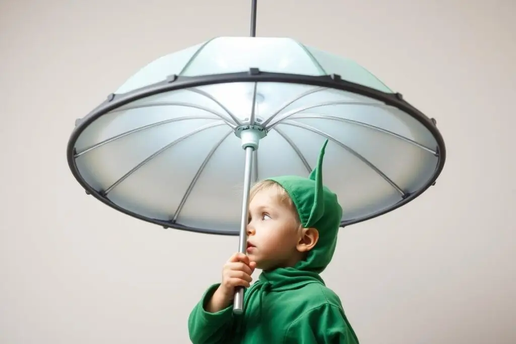 Dziecko w kompletnym stroju UFO z zielonym ubraniem i antenkami na głowie