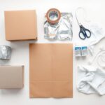 Materiały potrzebne do wykonania stroju kosmicznego dla dziecka, w tym karton, folia aluminiowa, taśmy i farby